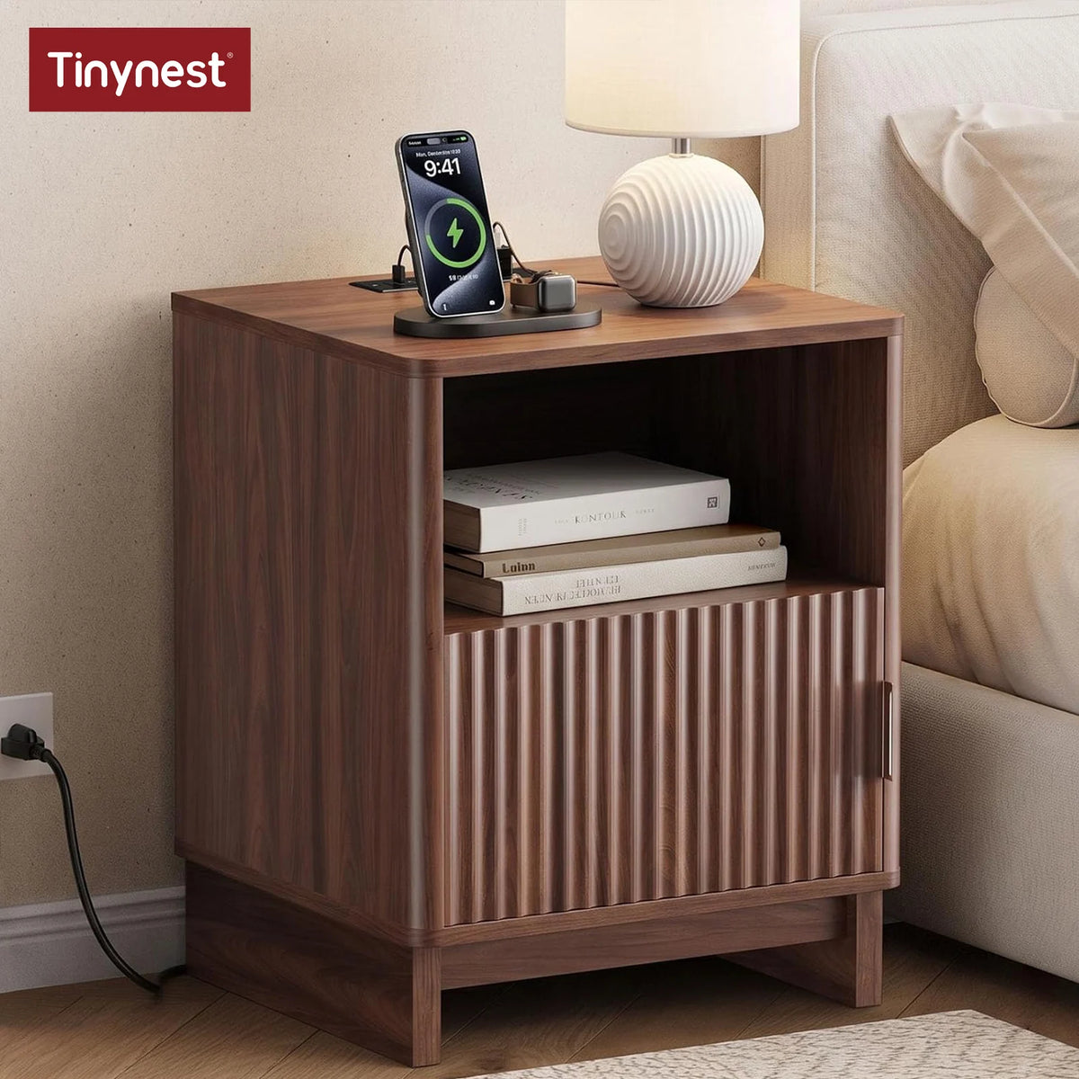 TinyNest nightstand in dark wood with fluted front panels and open lower shelf, phone charger on top.