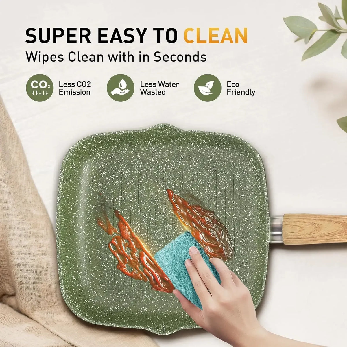 Green speckled square nonstick grill pan with wooden handle being wiped clean with a blue sponge.