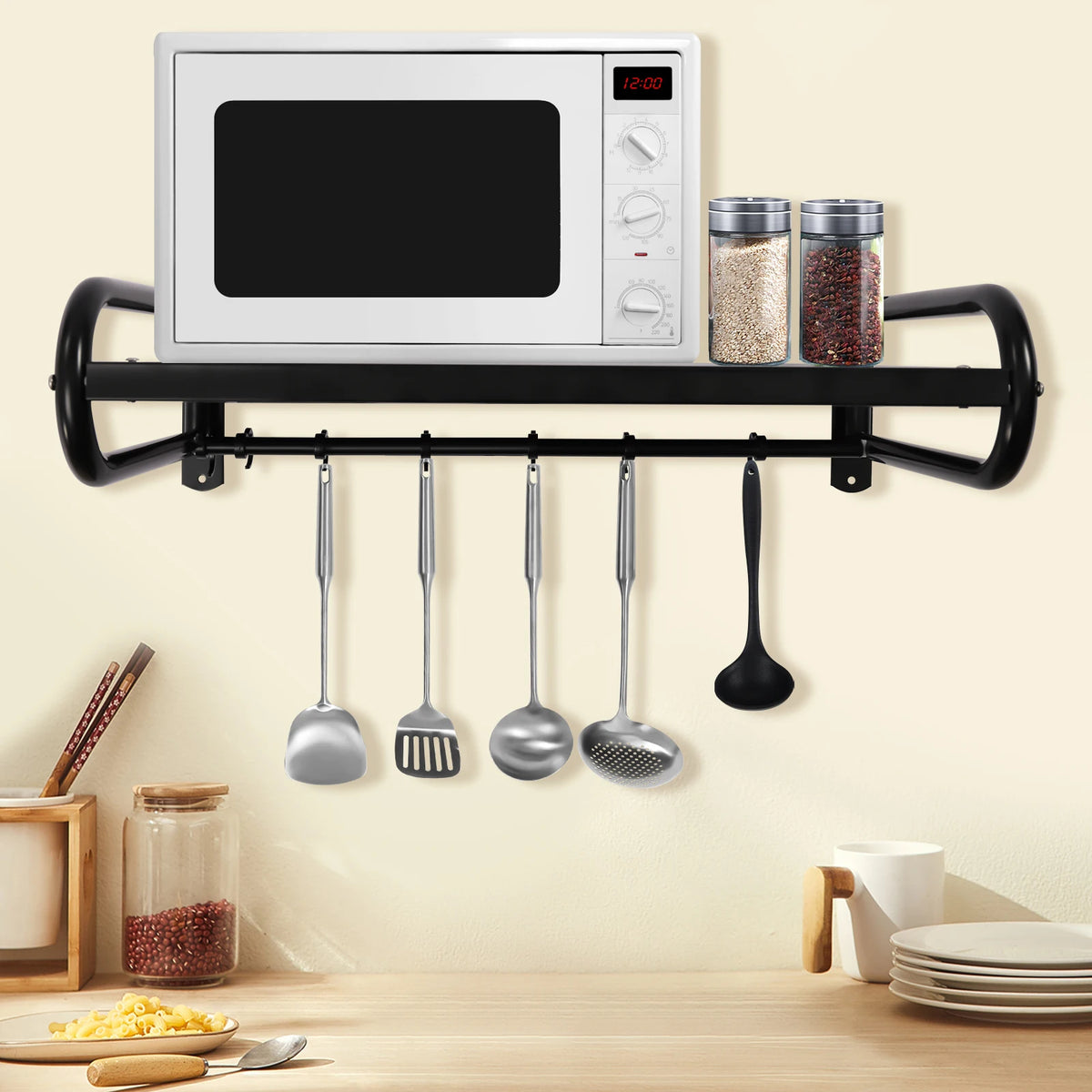 Carbon steel wall shelf in black with microwave on top, two glass spice jars, and six hanging utensils