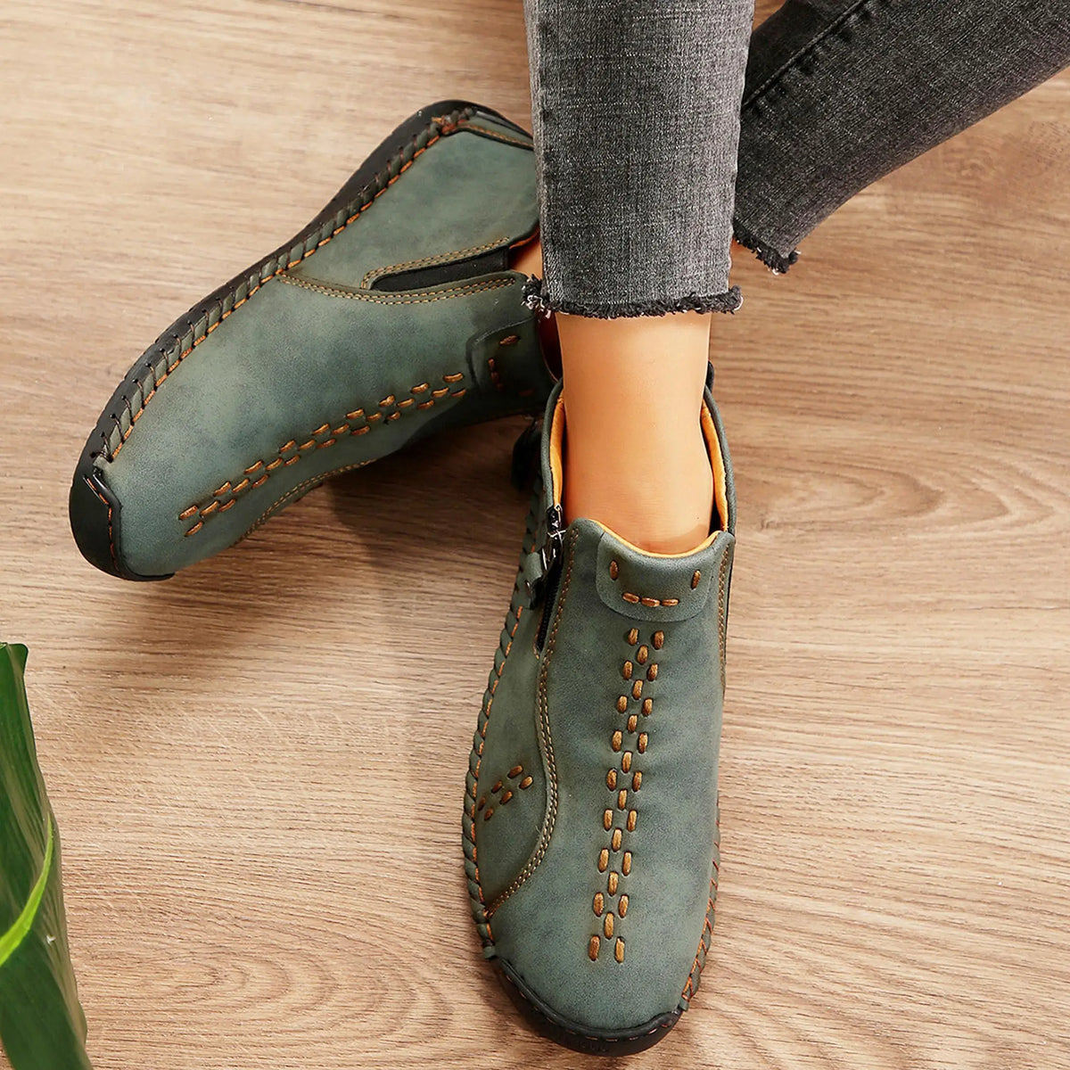 Green women's slip-on moccasin loafers with orange stitching; mid-top casual driving shoes.