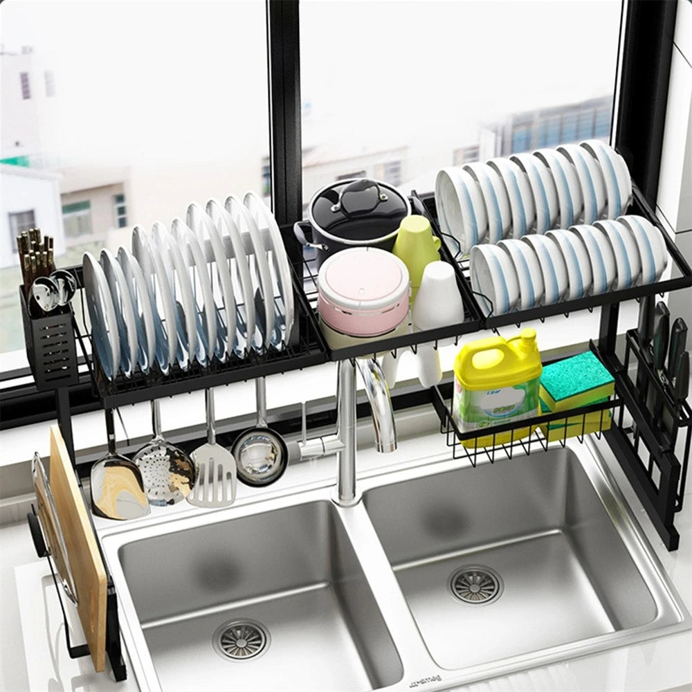 Over-the-sink black metal dish drying rack with utensil/knife holders and hooks for plates, bowls, and cups.