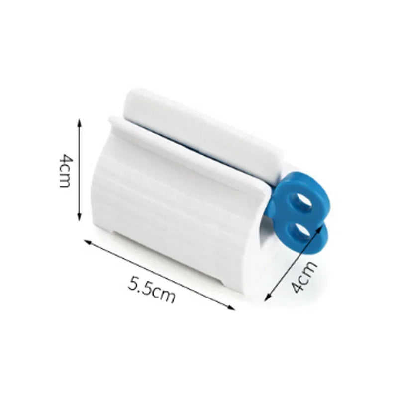 Toothpaste tube squeezer by S And B Enterprise, white plastic with blue ring handles, compact 5.5 cm by 4 cm.