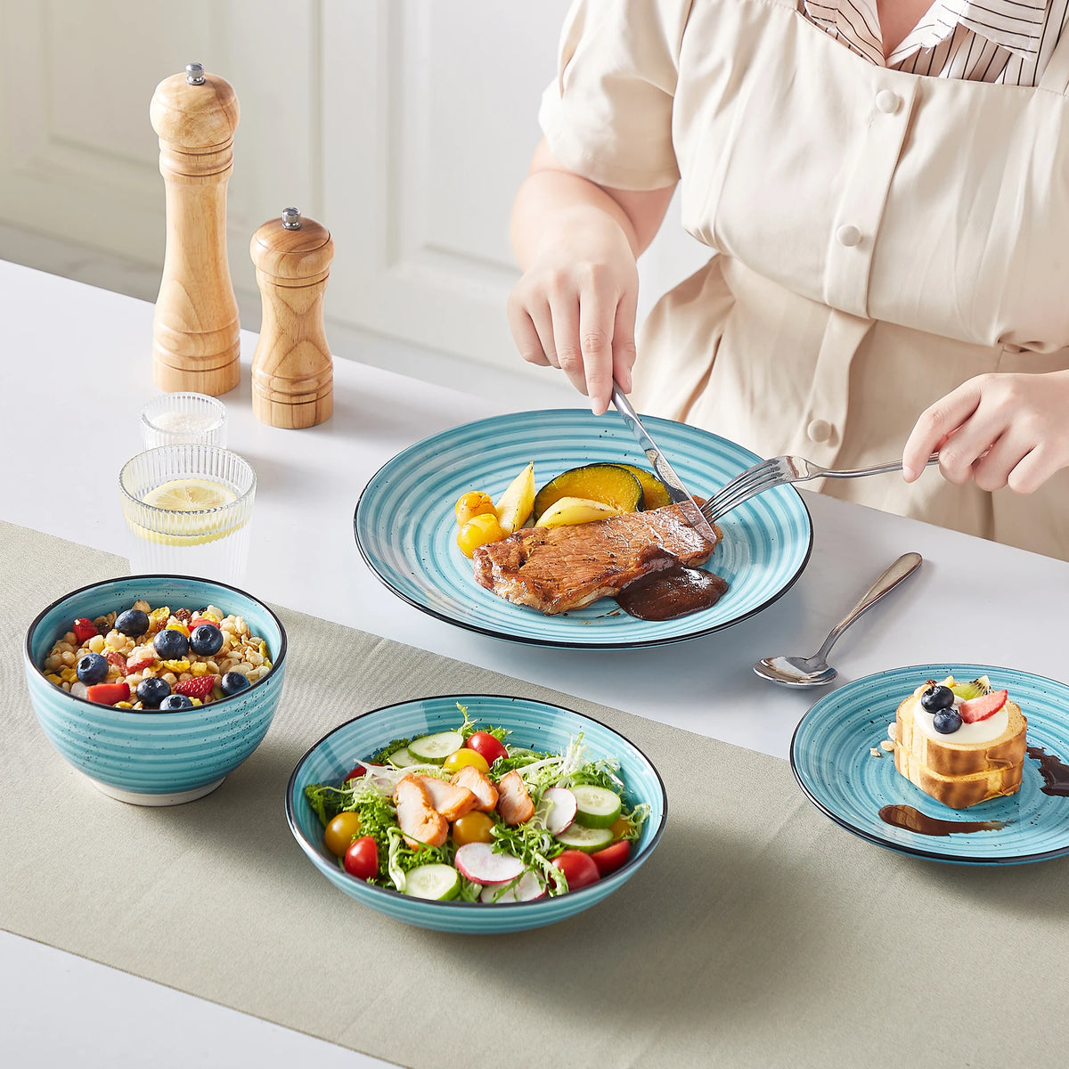 Blue ceramic dinnerware set with hand-painted spiral pattern; plates and bowls on table