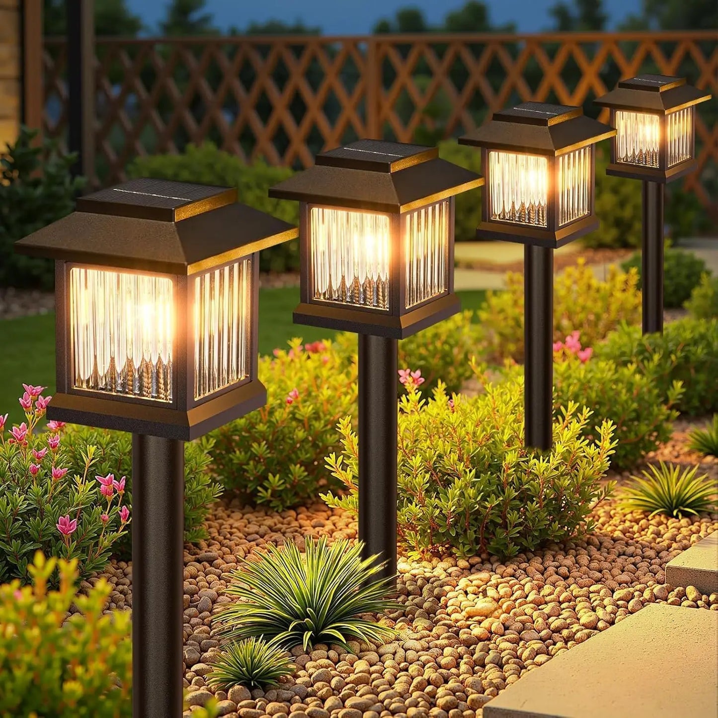 Solar pathway lights by S And B Enterprise; four bronze lanterns with glass panels along a pebble garden path.