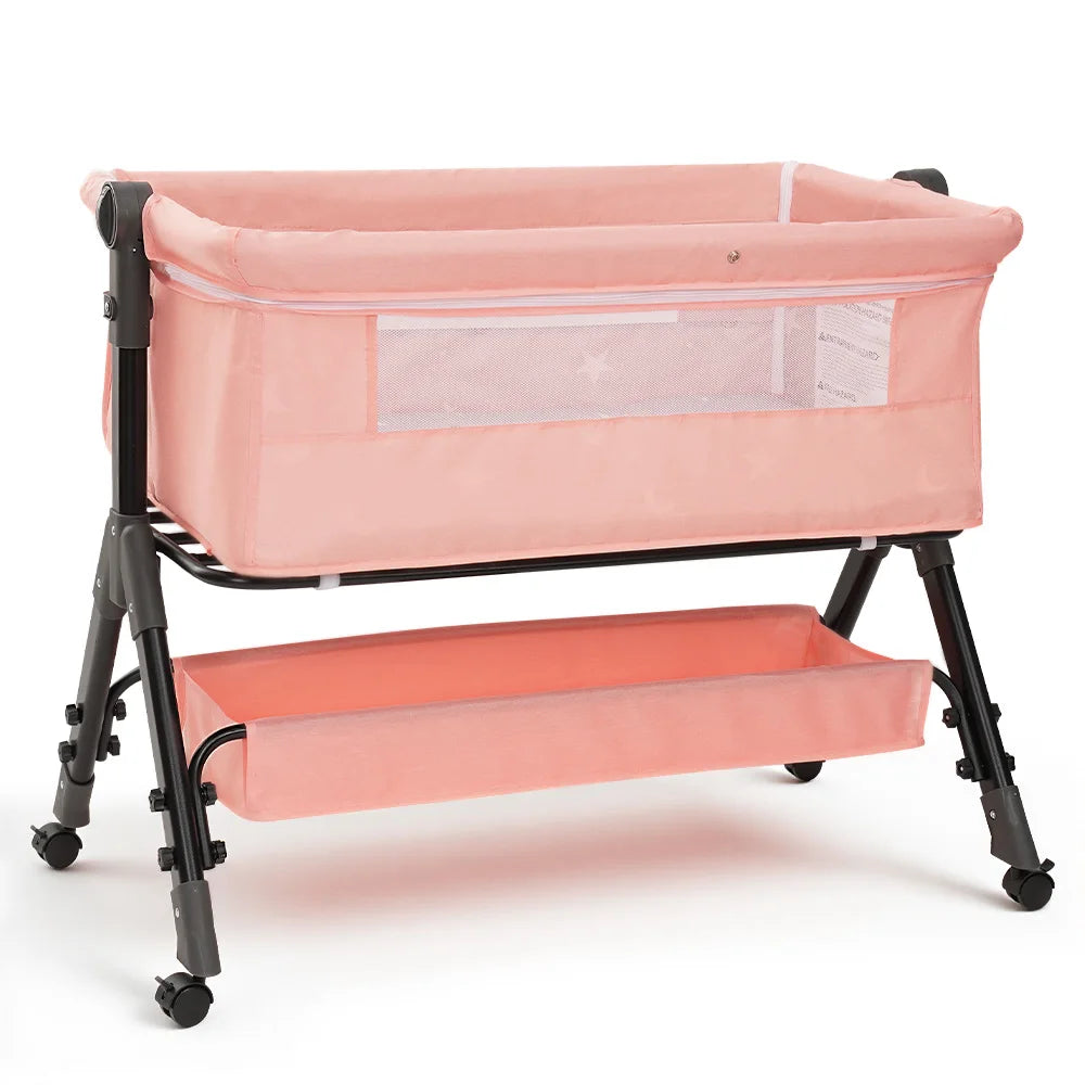 Pink foldable baby bassinet with mesh panel on a black wheeled frame; 3-in-1 bedside sleeper.