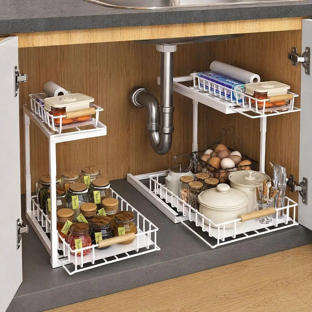 Two white metal 2-tier under-sink organizers with slide-out shelves under a cabinet.