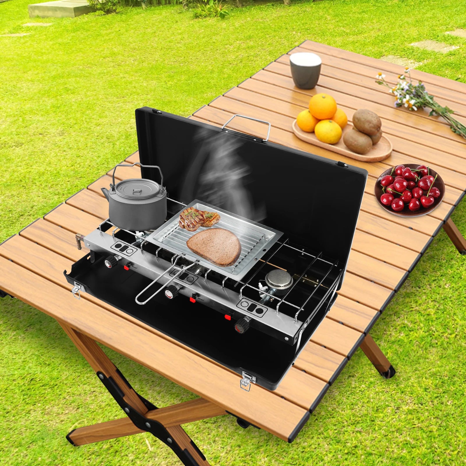Portable tabletop 3-burner camping stove by S And B Enterprise with non-slip feet on a wooden picnic table outdoors