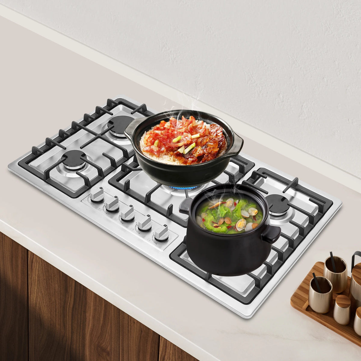 5-burner stainless steel built-in gas cooktop with cast-iron grates, two pots cooking.