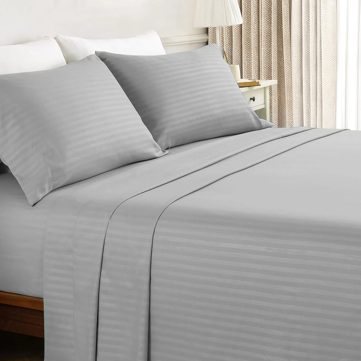 Battilo bed sheets 4-piece set in light gray with striped flat sheet and pillowcases on a neatly made bed