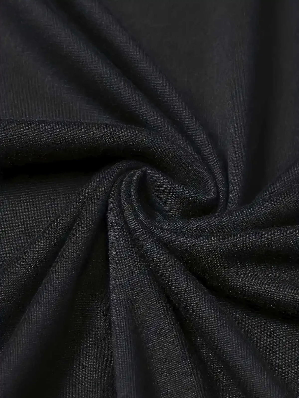 Men's T-shirt fabric close-up in black, plain knit with visible texture and folds