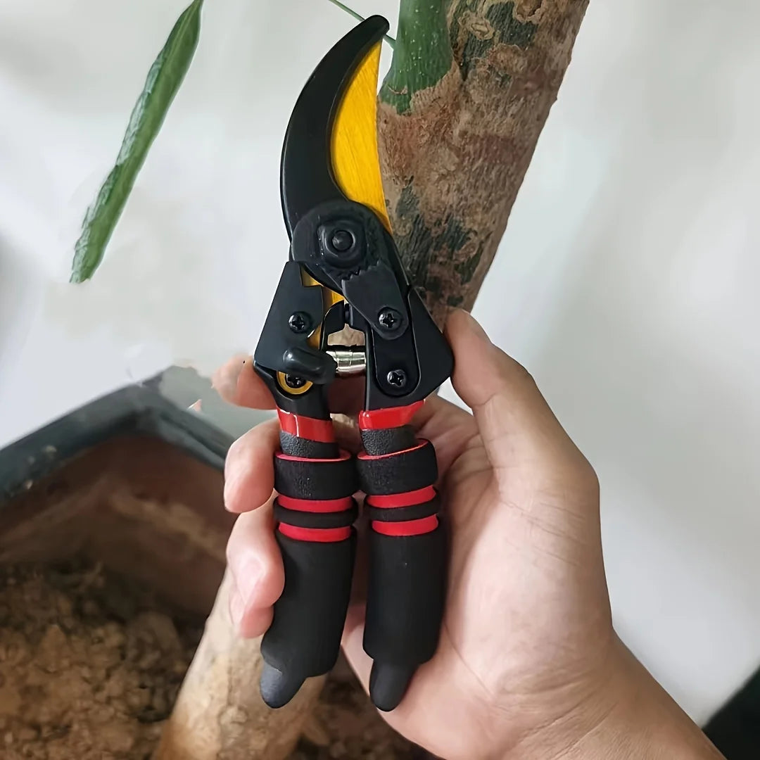 S And B Enterprise pruning shears with yellow SK-5 blade, black body and red-grip handles trimming a branch