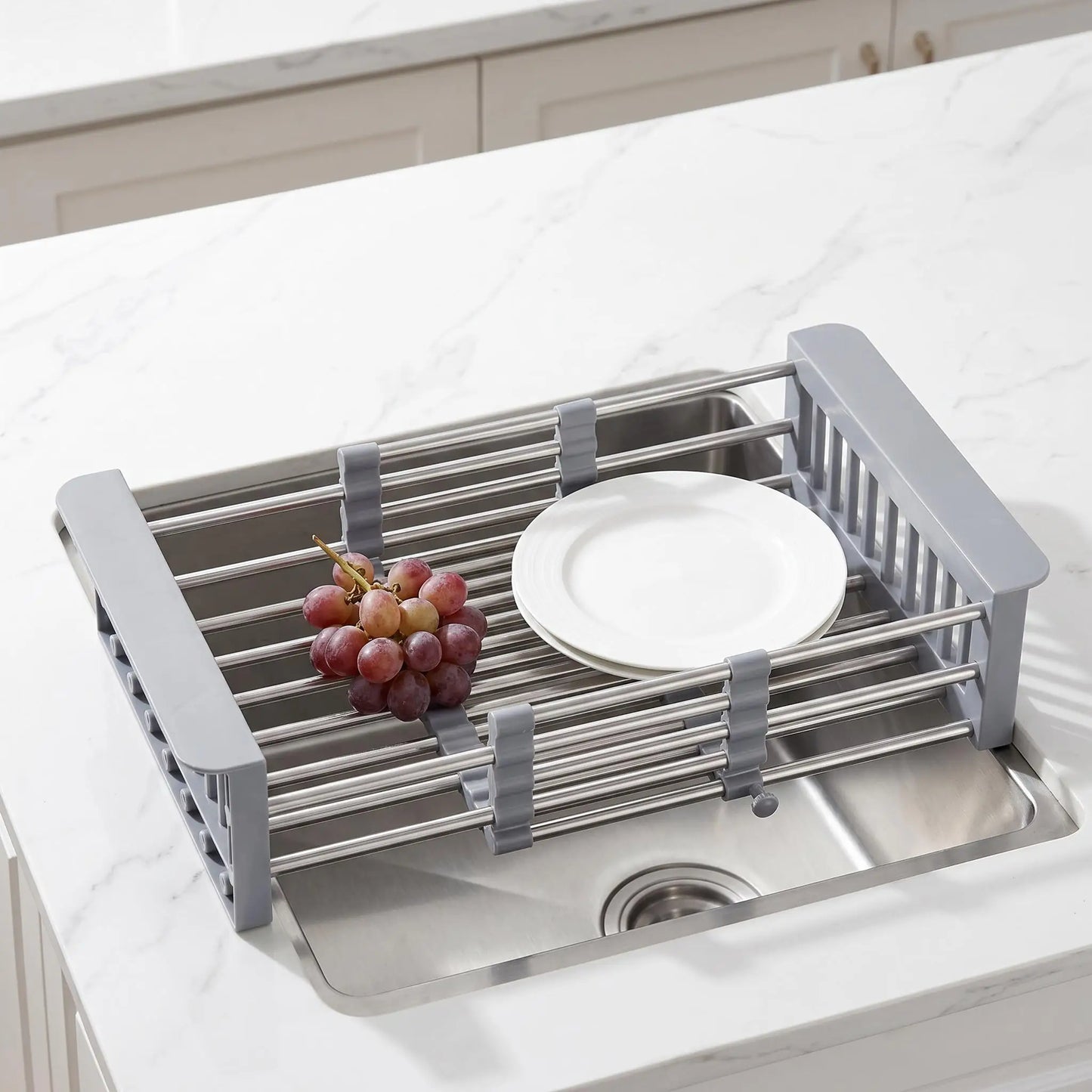 Adjustable stainless steel dish drying rack over sink with two plates and a grape cluster by S And B Enterprise