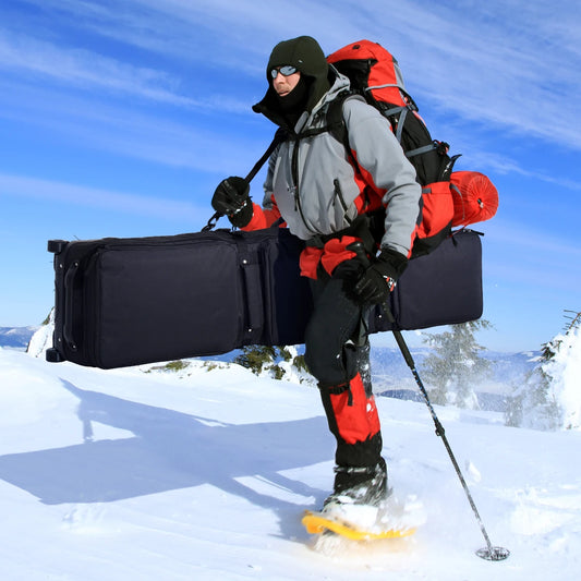 600D fully padded snowboard bag, black waterproof wheel travel bag carried by a climber in snowy mountains.