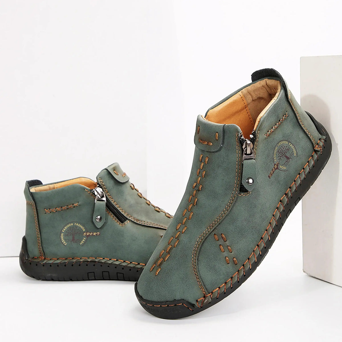 Womens green leather ankle boots with brown stitching, side zipper and circular logo patch.