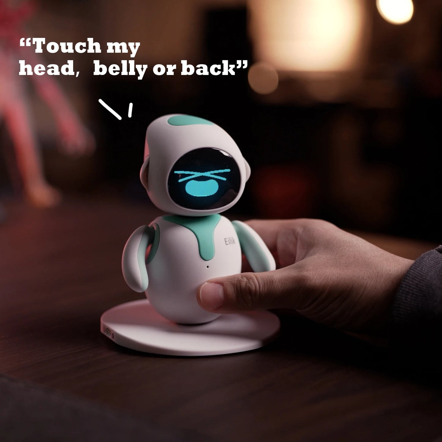 Eilik robot toy with teal accents and white body, held on a circular white desk stand
