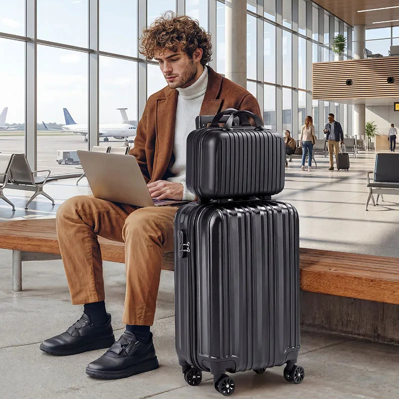 2-Piece black hardside luggage set by S And B Enterprise with stacked suitcases at the airport.