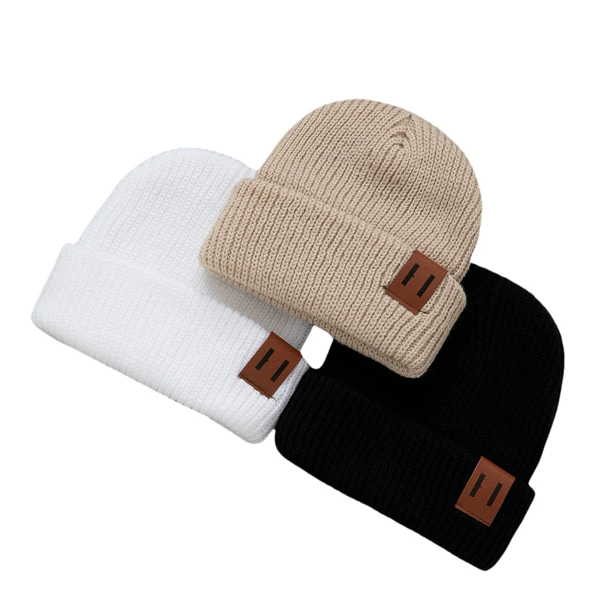 3-pack knitted baby beanies in white, beige and black with brown patches