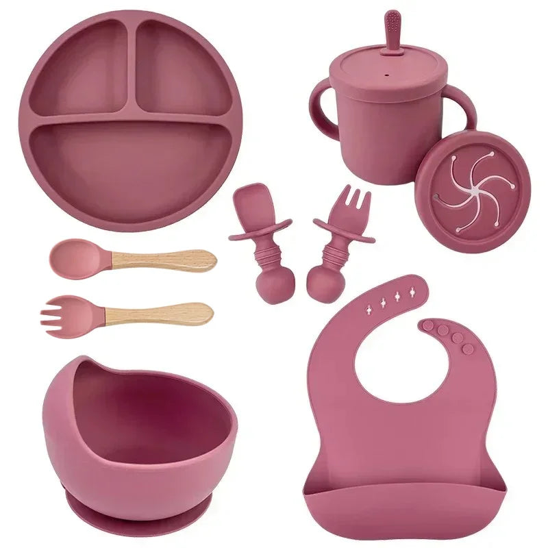 Pink silicone baby feeding set by S And B Enterprise; includes plate, suction bowl, cup with lid and straw.