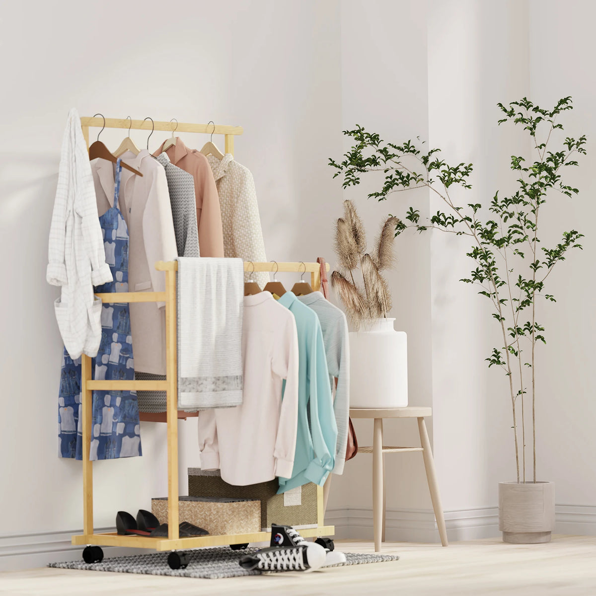 Natural bamboo double hanging clothes rack on wheels with storage shelves and pastel clothing.