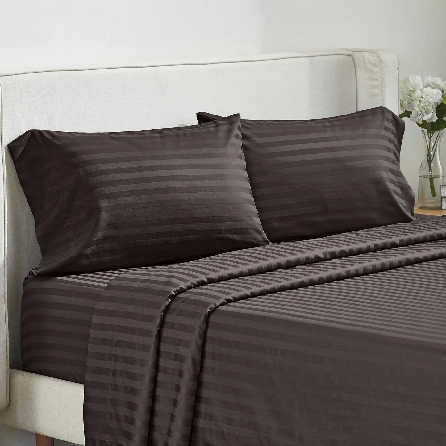 Battilo 4-piece bed sheet set with brown striped pillowcases on a beige upholstered bed