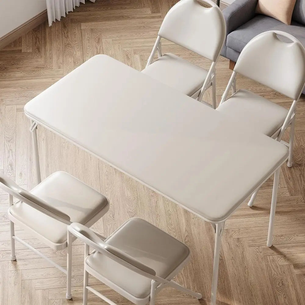Portable folding card table with four white folding chairs.