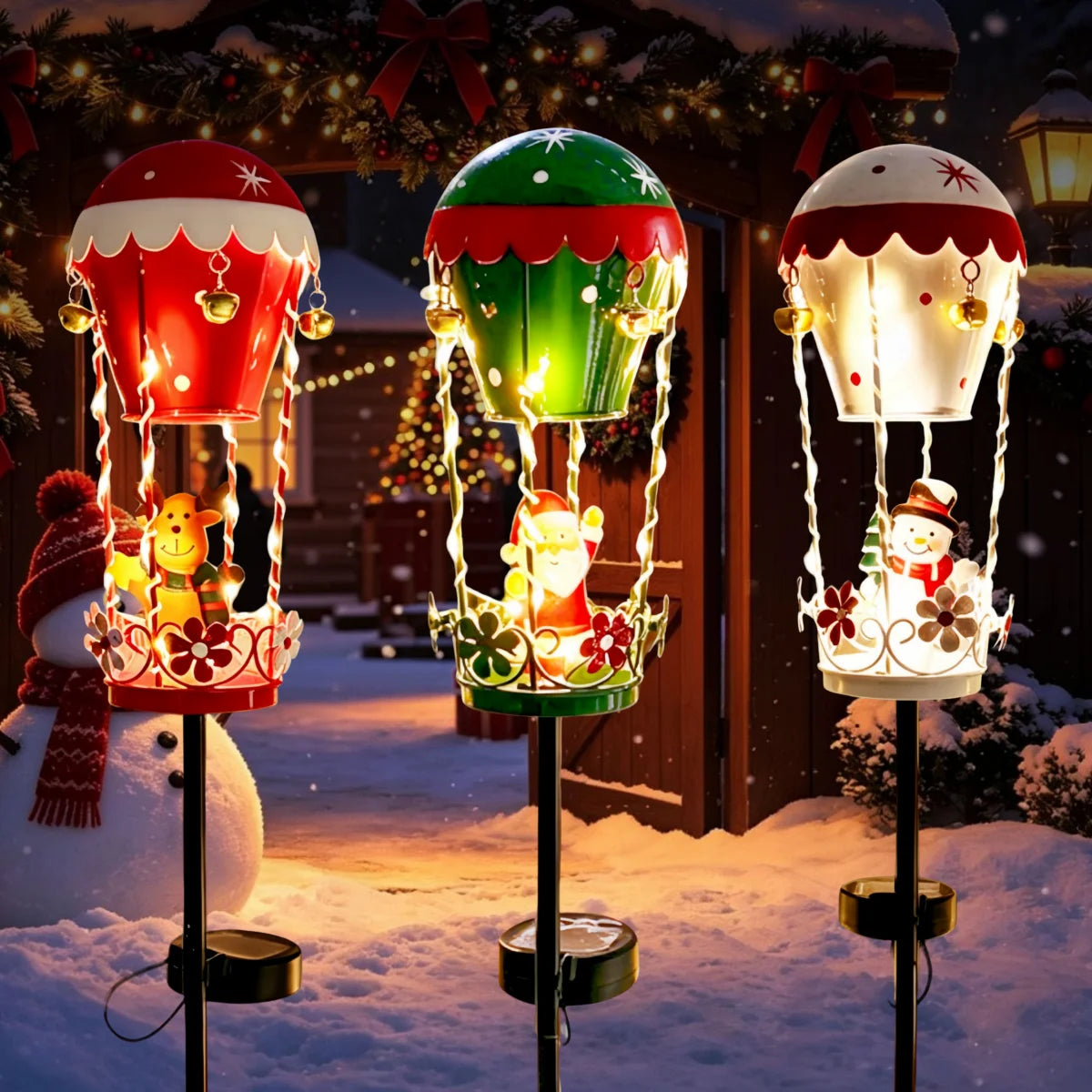 Outdoor garden solar stake lights by S And B Enterprise; three iron Santa hot-air balloon figures with bells and lights.