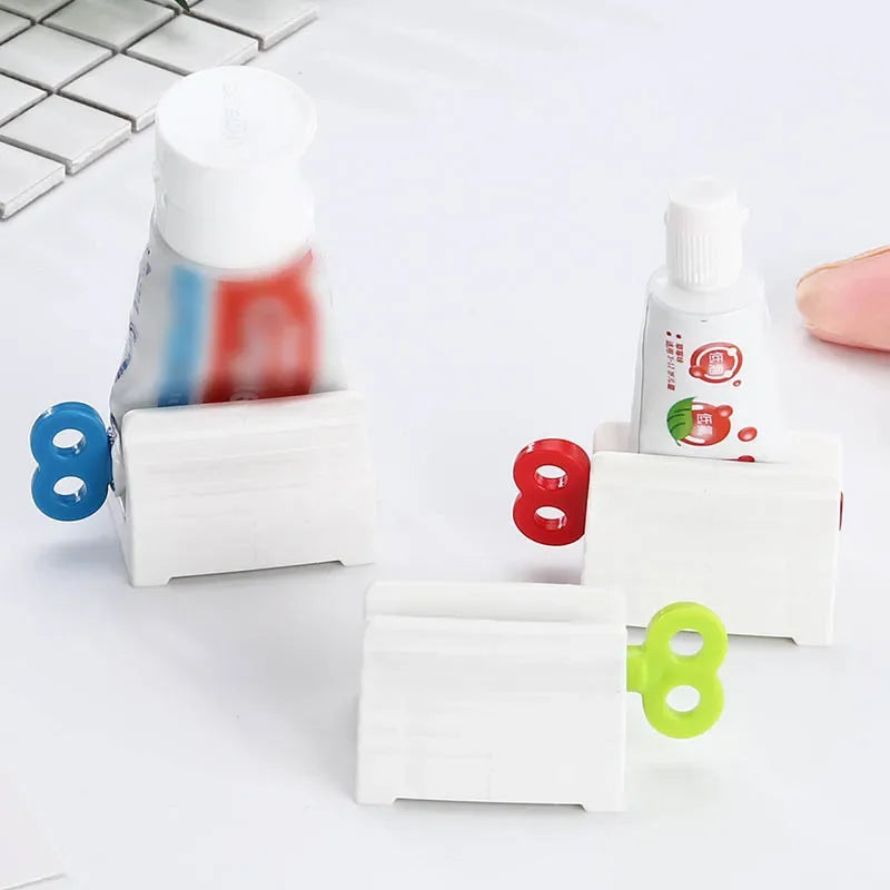 Toothpaste tube squeezers by S And B Enterprise; three white plastic units with blue, red and lime handles.