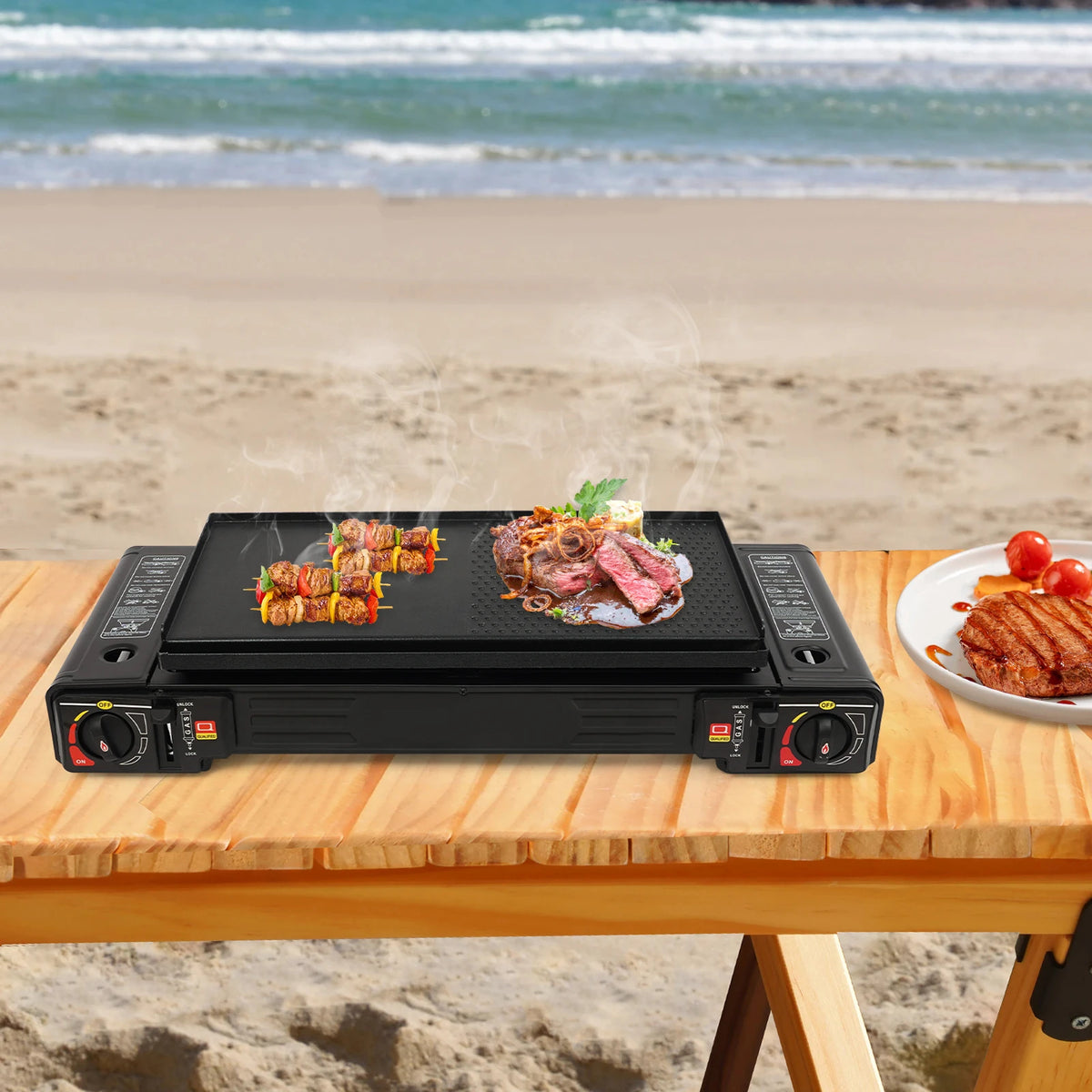 2500W portable camping stove by S And B Enterprise; black dual-burner grill cooking skewers and steak at the beach