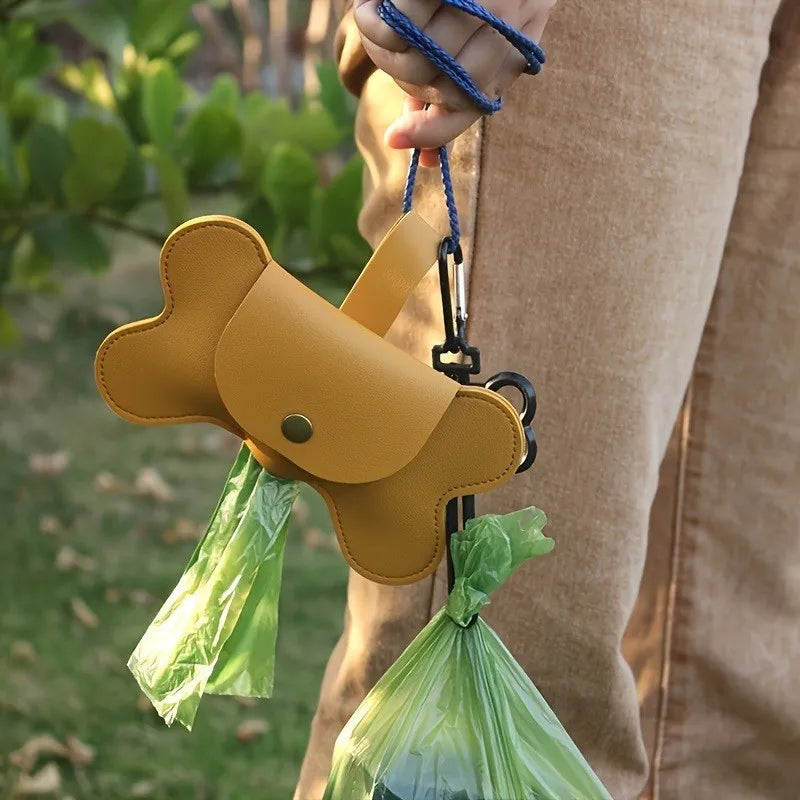 Dog poop bag dispenser by S And B Enterprise, tan bone-shaped with two attached green bags