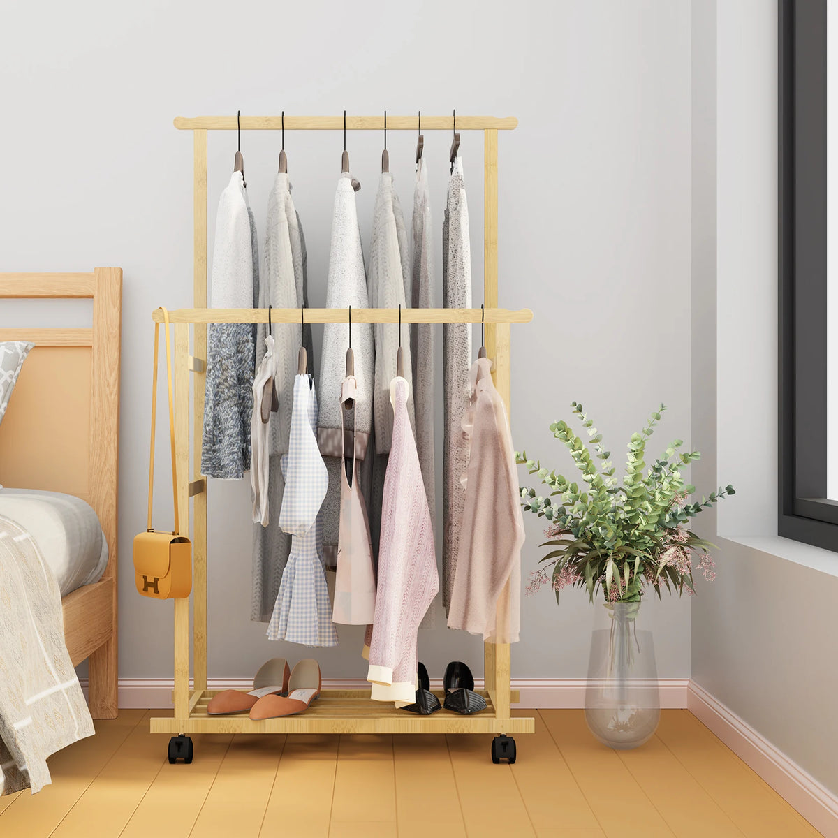 Bamboo clothes rack with double hanging rails on wheels and storage shelves in natural wood finish.