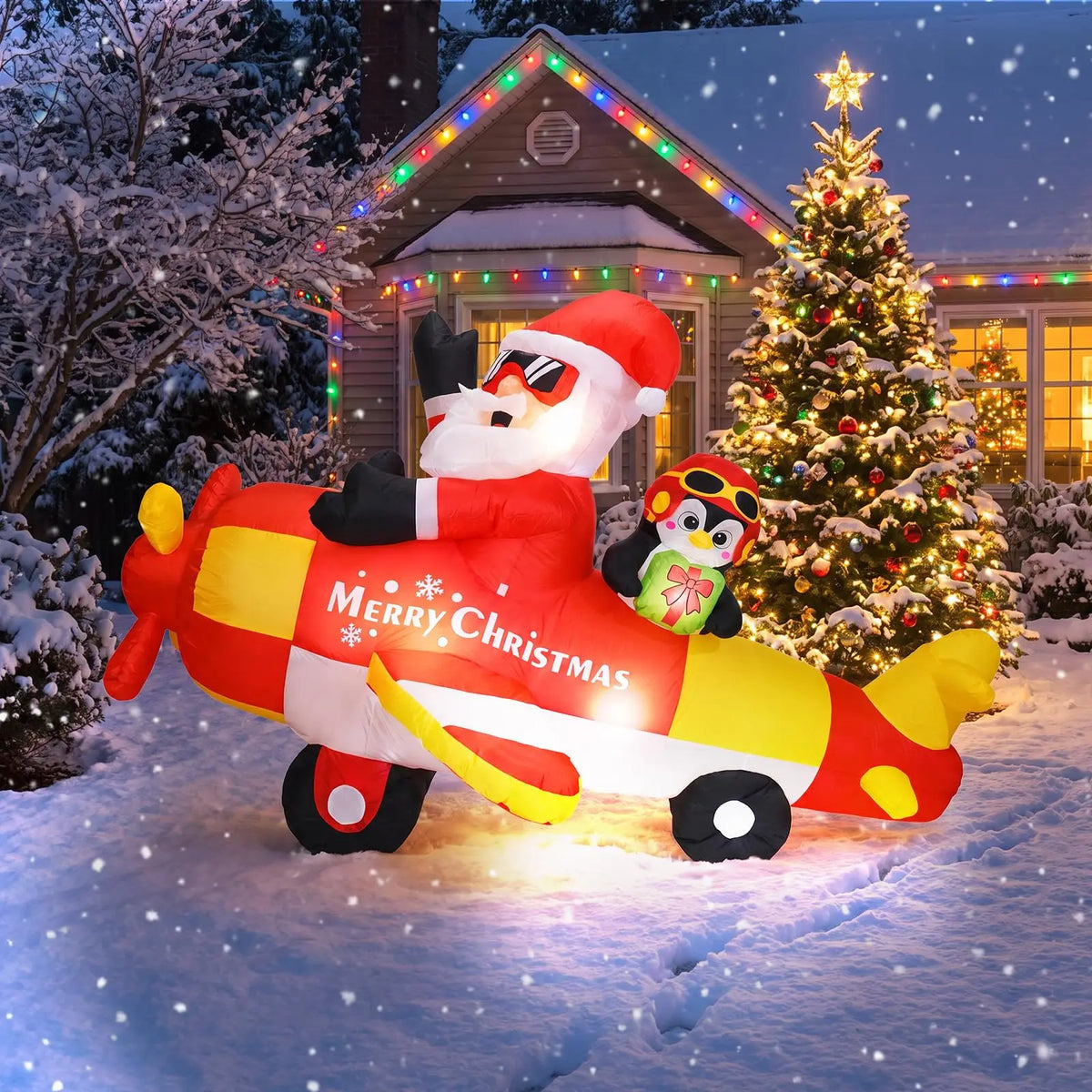 8ft inflatable Christmas Santa driving penguin airplane on a snowy lawn with colorful lights and a decorated Christmas tree