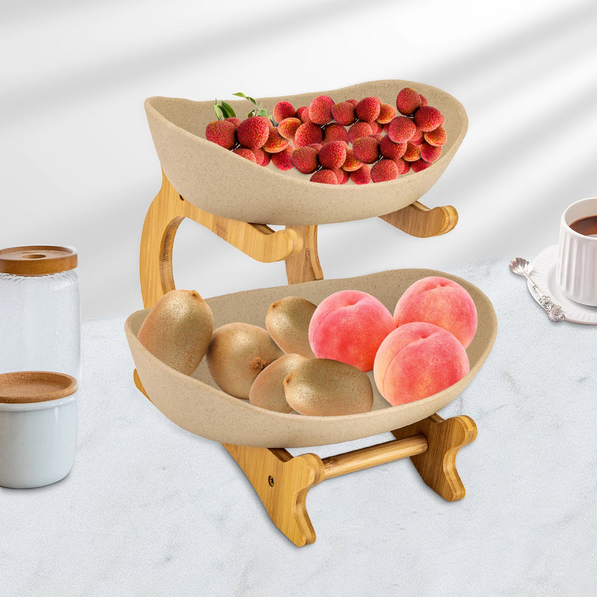Two-tier fruit bowl on a natural wooden stand with beige ceramic bowls, filled with lychees, peaches and pears.