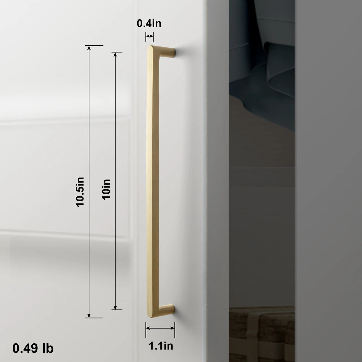 Solid brass cabinet handle pull on white cabinet door; long slender furniture hardware