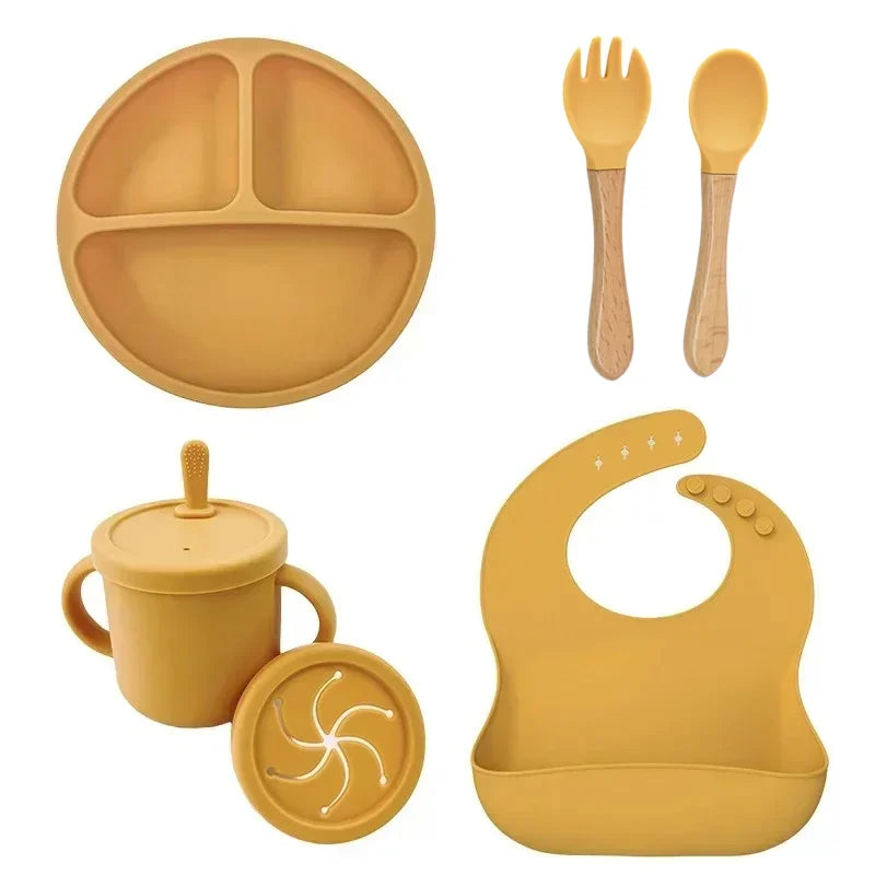 Yellow 6-piece silicone kids feeding set with suction plate, wooden-handle spoon and fork, cup, and bib