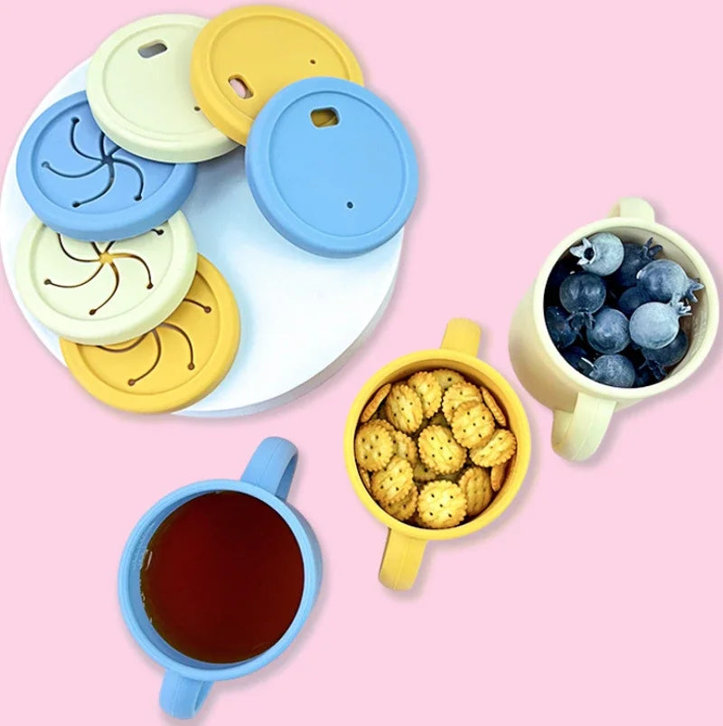 Food-grade silicone toddler dish set with suction bowls and cups in pastel blue, yellow, and mint