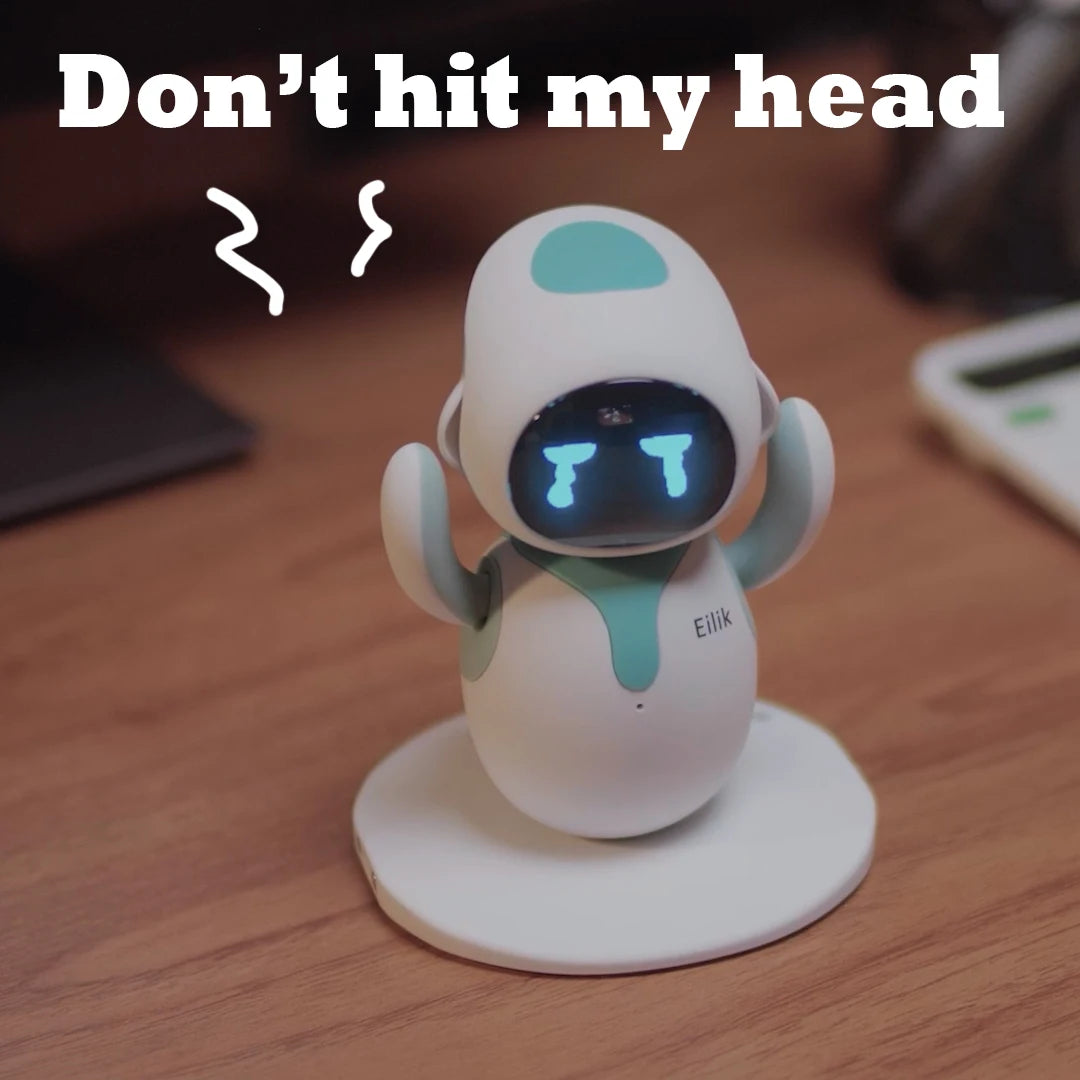 Eilik robot pet toy on a round white base; white with teal accents and glowing blue eyes