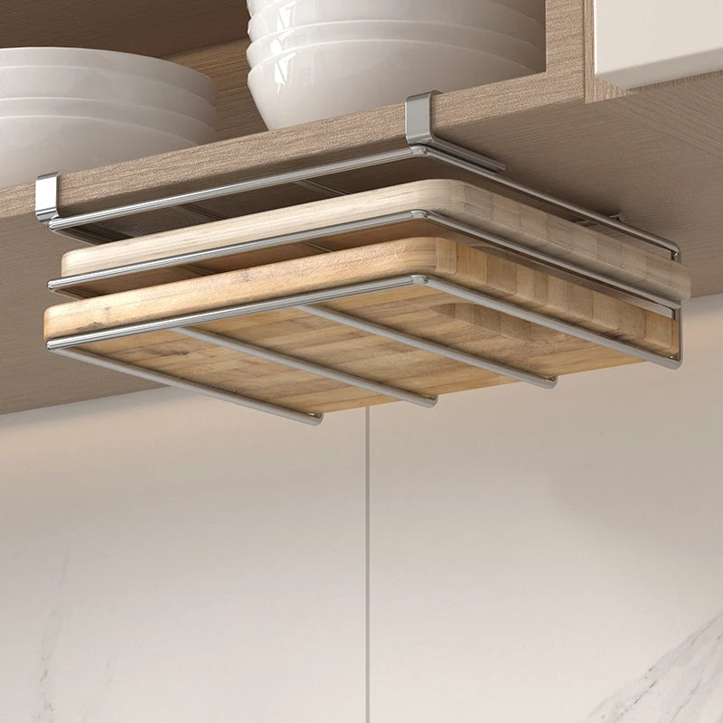 Under-cabinet stainless steel cutting board organizer holding three wooden boards