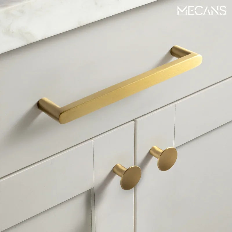 3-piece solid brass cabinet pull set with a long bar handle and two round knobs on a white cabinet with countertop