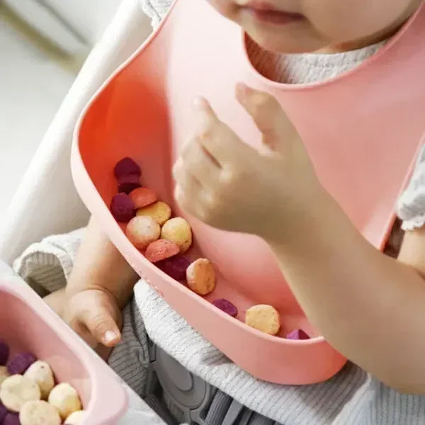 Two pink silicone child feeding plates with suction bases; part of a baby tableware set