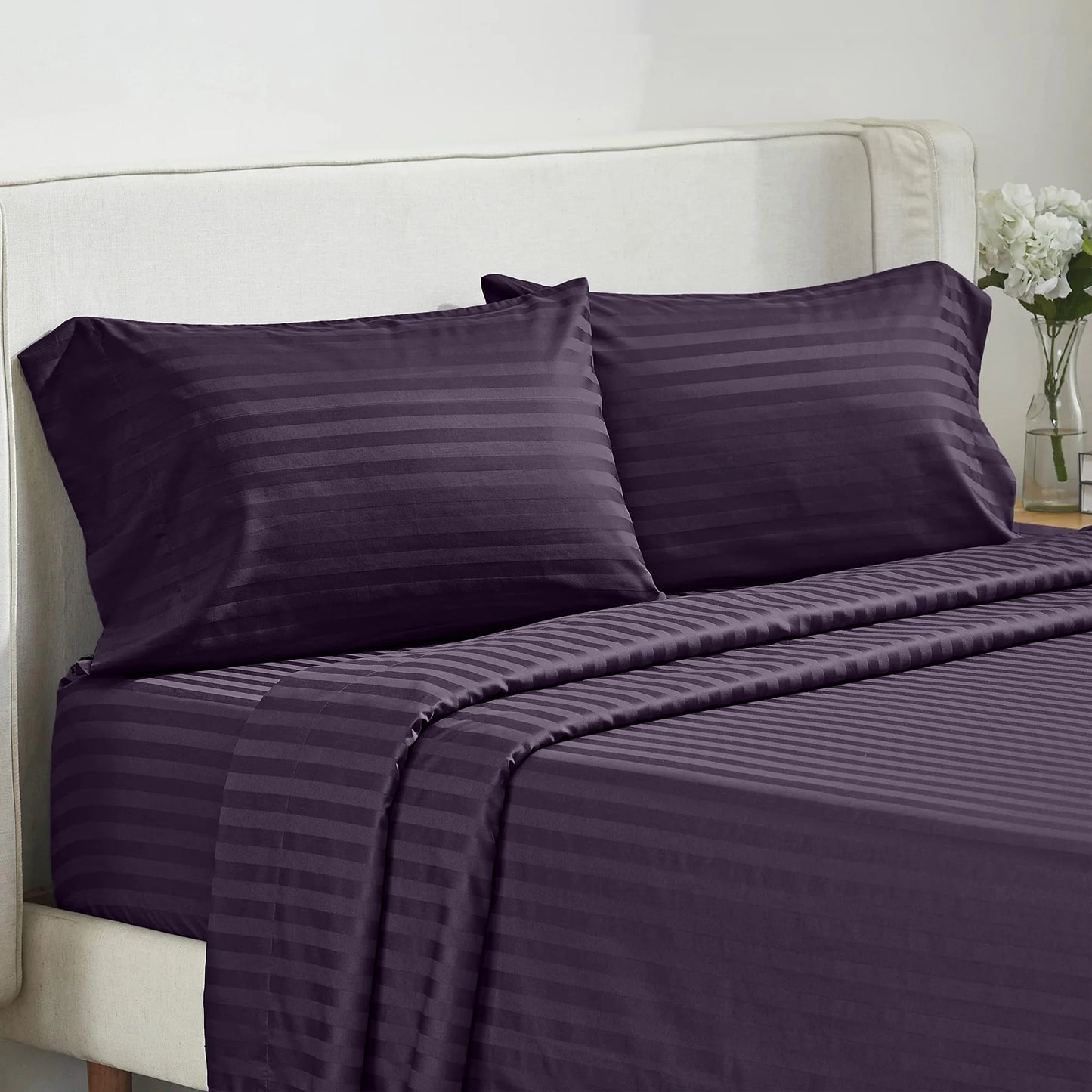 Battilo 4-piece purple striped bed sheet set with pillowcases on a beige upholstered bed