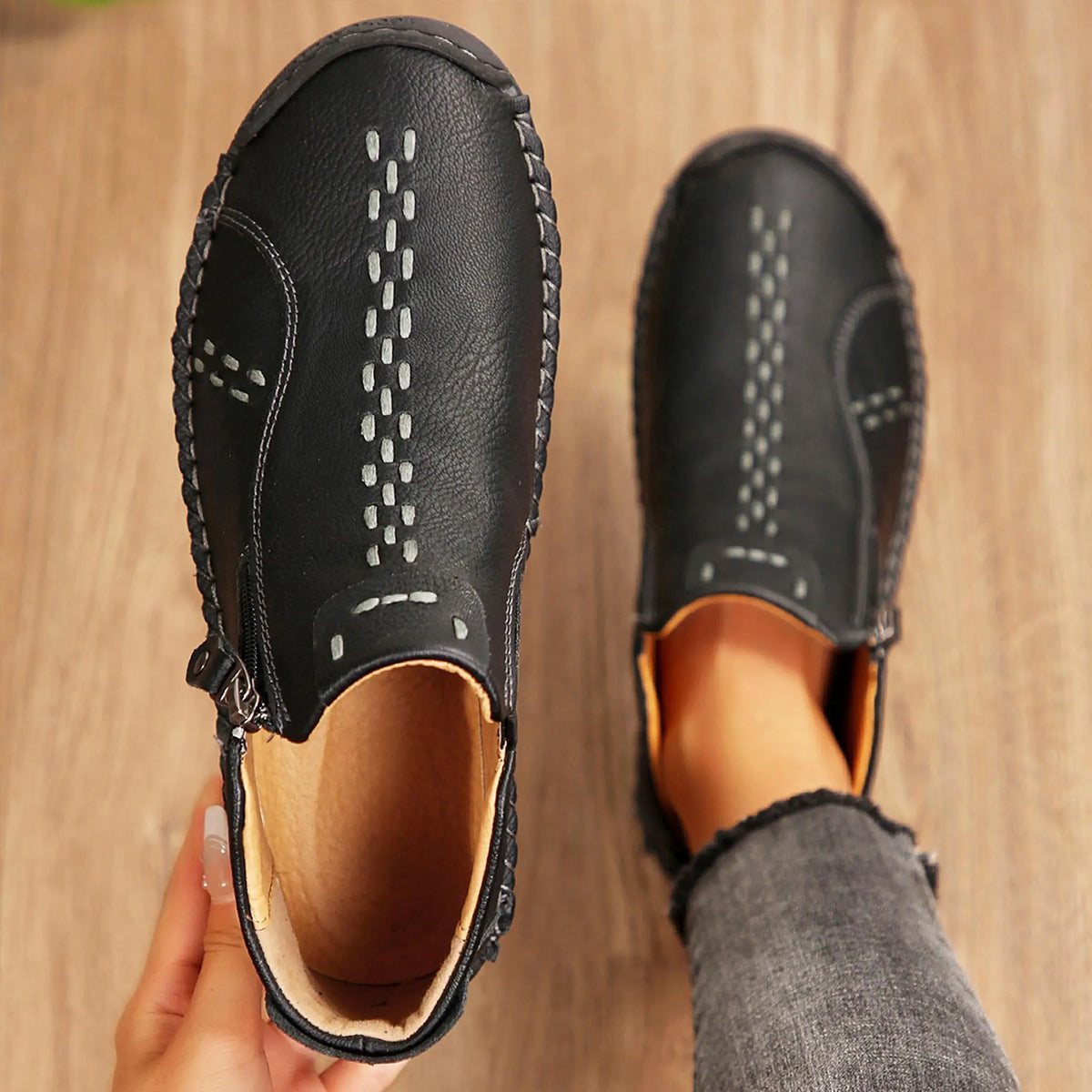 Women's black leather slip-on loafers with white stitching, S And B Enterprise pair.