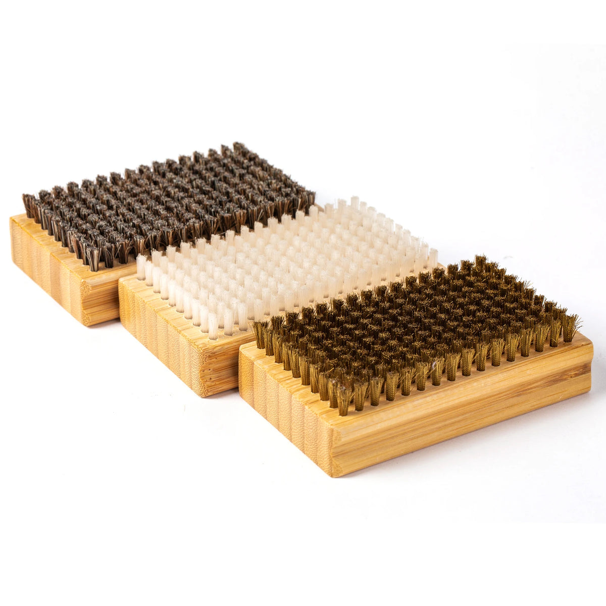 Three wooden ski wax brush blocks with brown, white, and bronze bristles