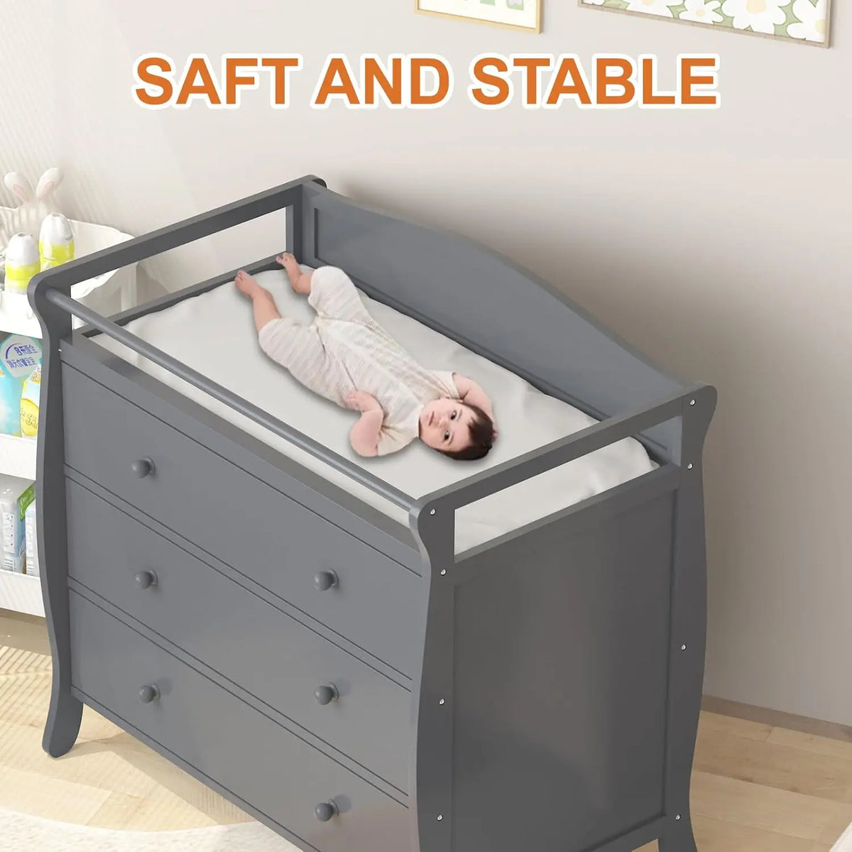 Gray wooden baby changing table with 3 drawers, safety rails, and changing pad.
