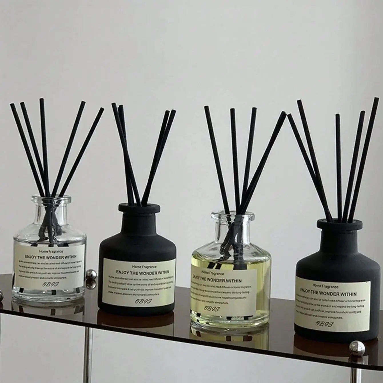 Flameless reed diffuser set, 50ml, freesia jasmine scent; four glass/black ceramic bottles by S And B Enterprise