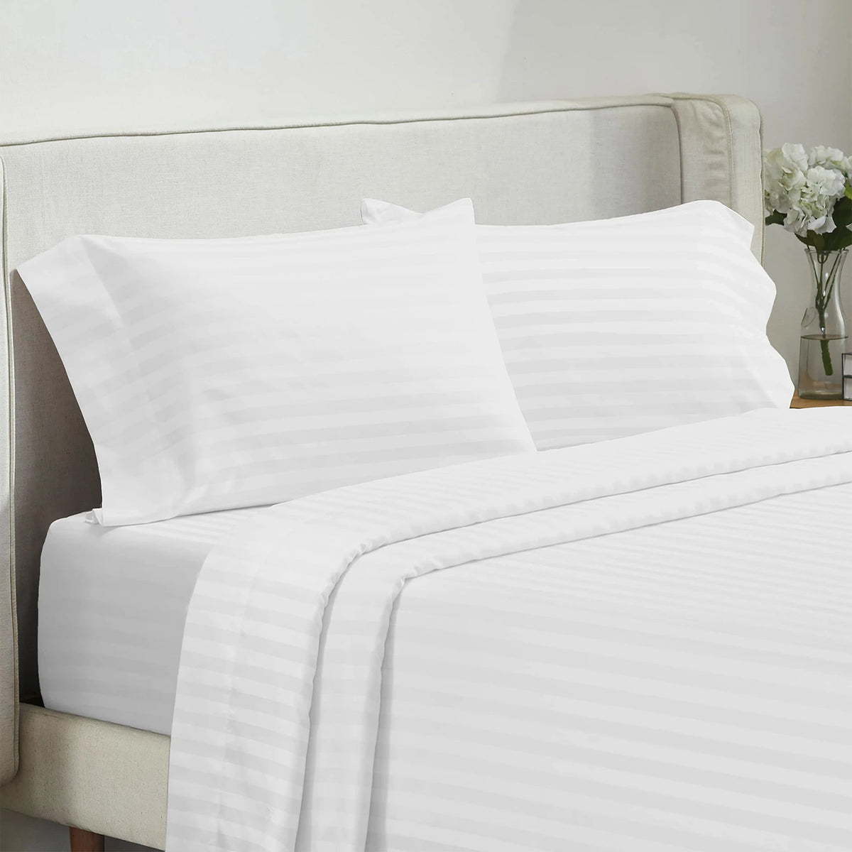 Battilo 4-piece bed sheet set with white striped sheets and two pillowcases on a bed