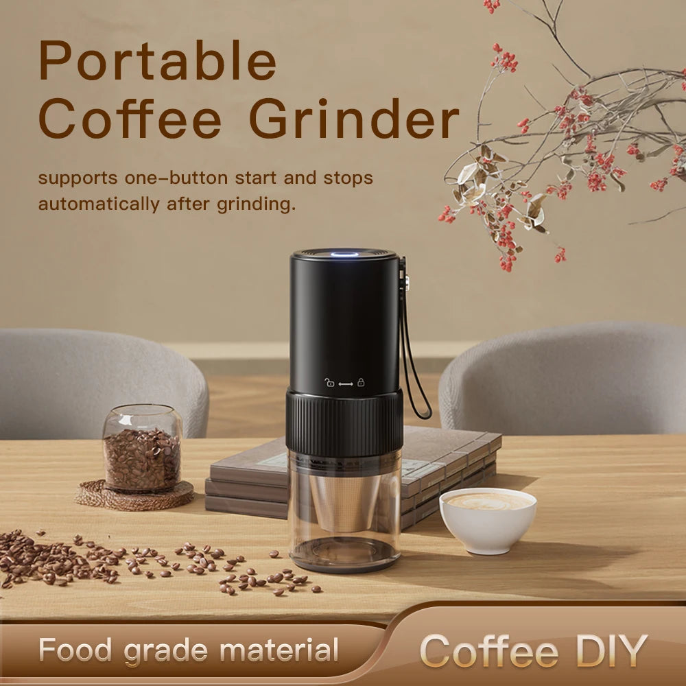Portable black electric coffee grinder with a clear container on a wooden table, surrounded by coffee beans and a cup.