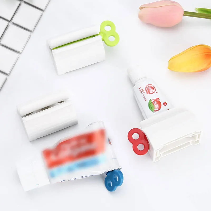 Toothpaste tube squeezers by S And B Enterprise; five white plastic devices with green, red, and blue handles.