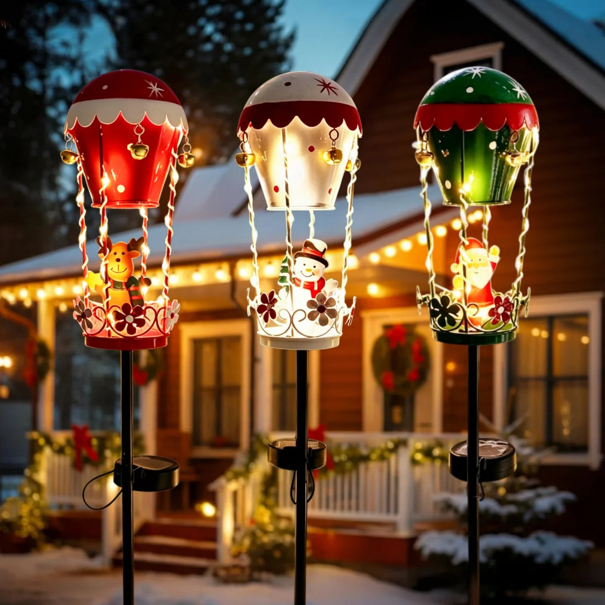 Outdoor garden solar stake light set with three iron Christmas Santa hot-air balloon statues lit with bells for yard pathway decor