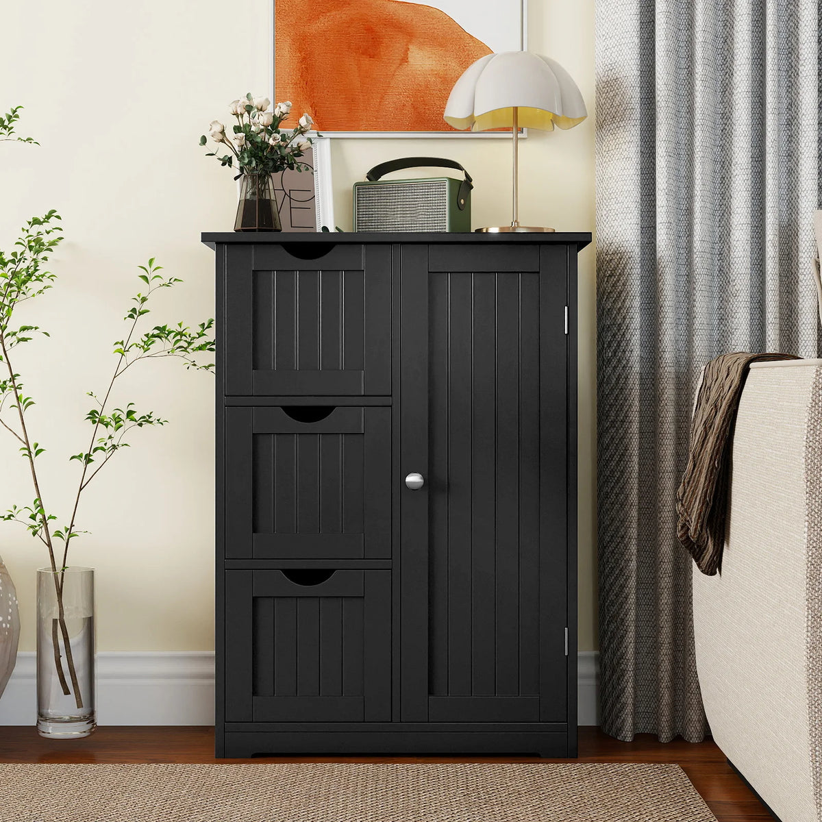 Black bathroom floor cabinet with three drawers and one cupboard; vertical paneled doors.