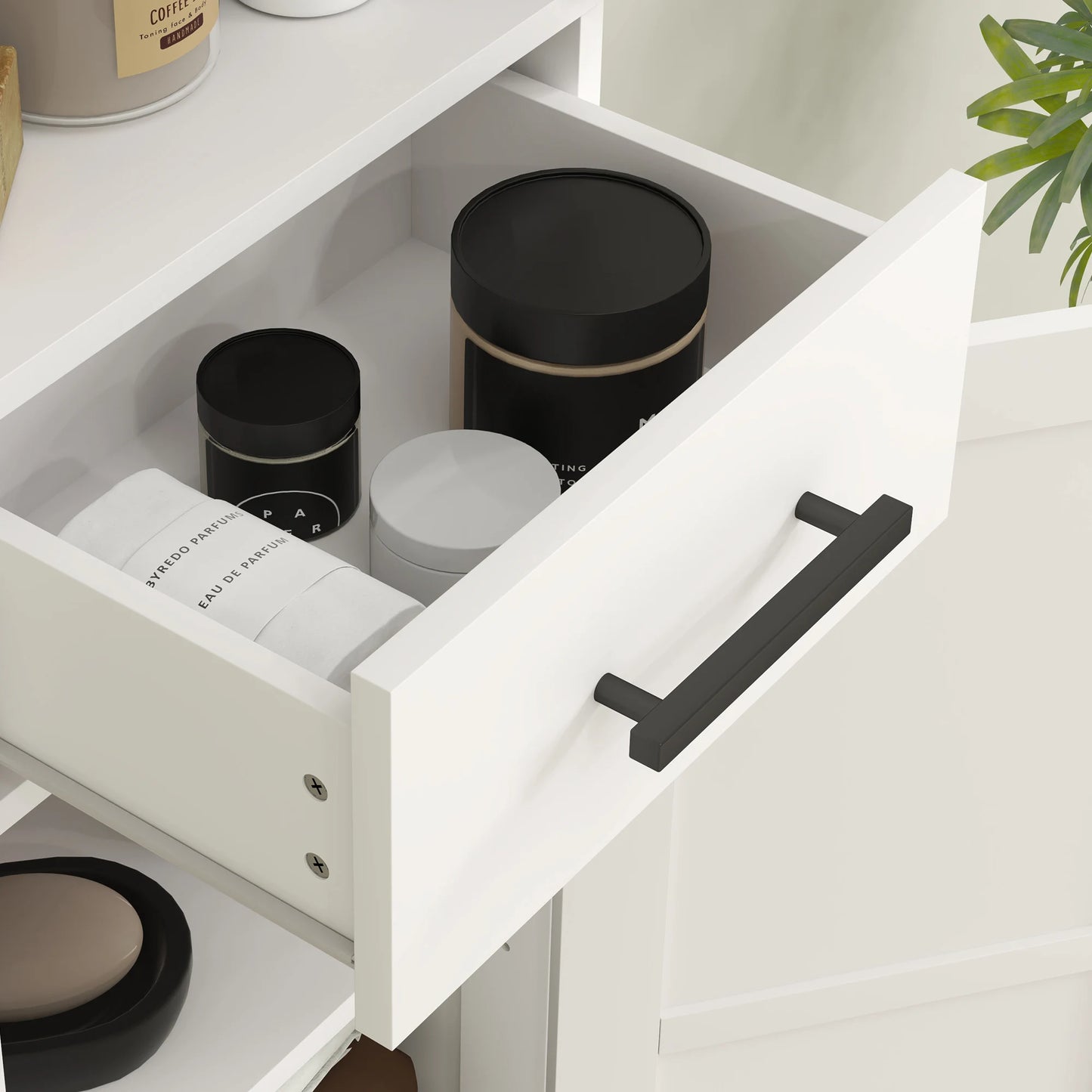 White tall bathroom storage cabinet with drawer, opened to reveal black round canisters inside.